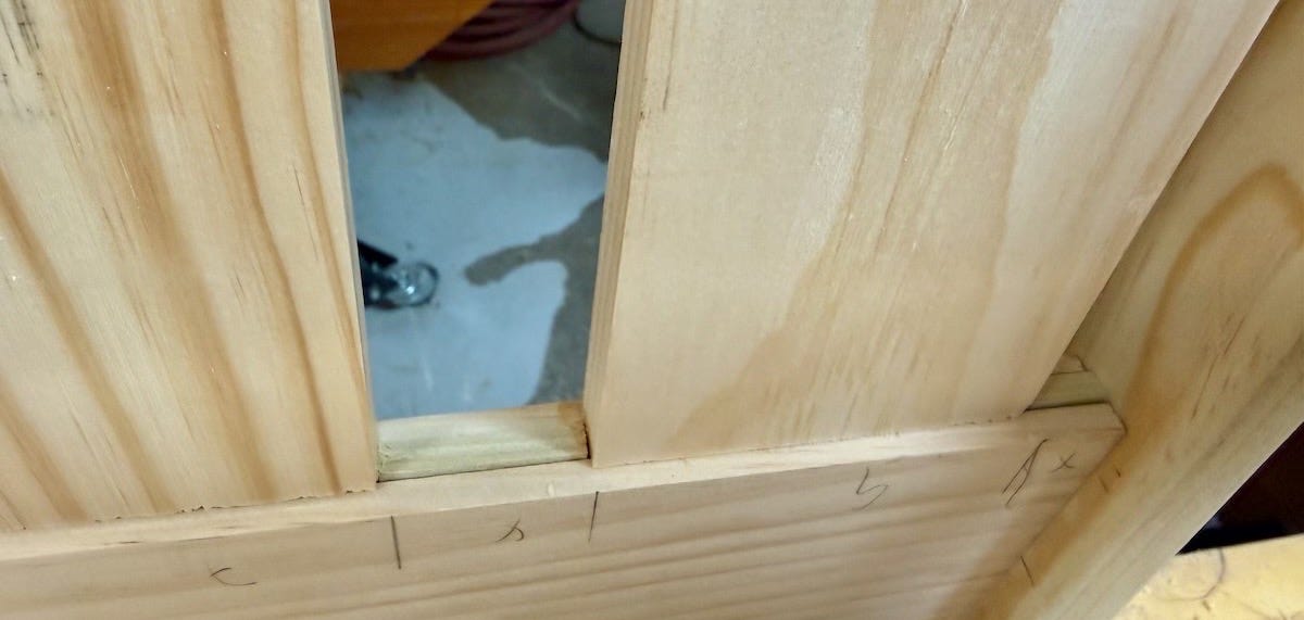 A close-up of the back rest of a porch swing, highlighting vertical slats that sit in horizontal rails, with small pieces of wood sitting between the slats. A close-up of the back rest of a porch swing, highlighting vertical slats that sit in horizontal rails, with small pieces of wood sitting between the slats.