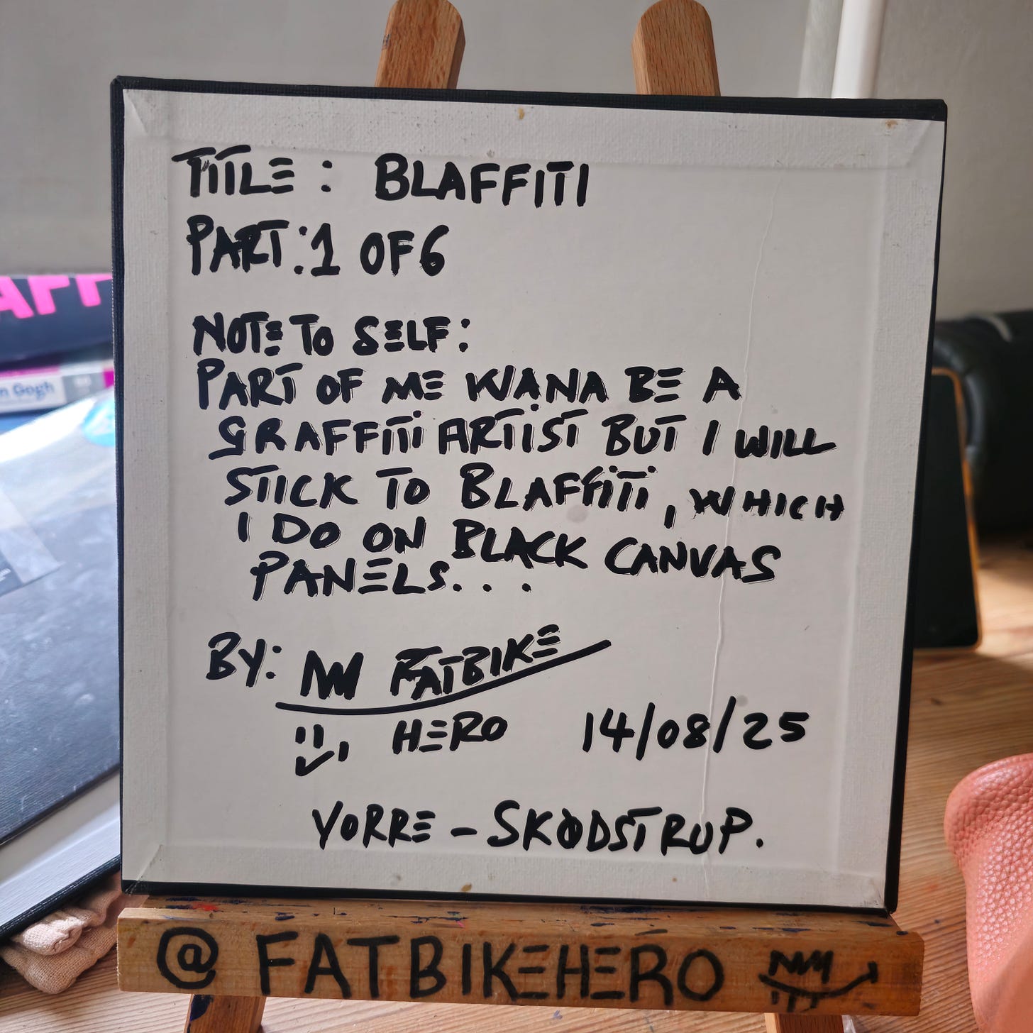 The back of a canvas panel showing handwritten notes by artist FatbikeHero, titled "Blaffiti Part 1 of 6" dated 14/08/25, with a "note to self" about the style.
