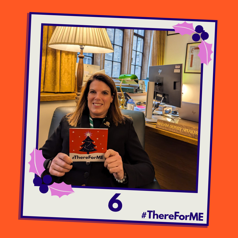 A pretend polaroid shows a smiling Caroline Nokes in her Deputy Speaker's office, posing for a photo holding a #ThereForME Christmas card.   The image on the card shows the dark blue Christmas tree, decorated with sparkling fairy lights, baubles and a star on the top, in a snowy landscape against a starry backdrop. The design is in the #ThereForME colours.