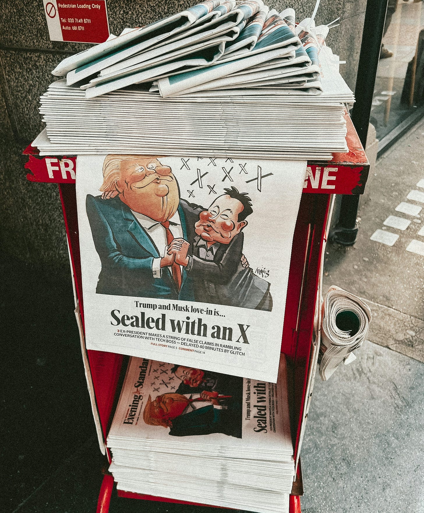 A newspaper stand with a bunch of newspapers on top of it