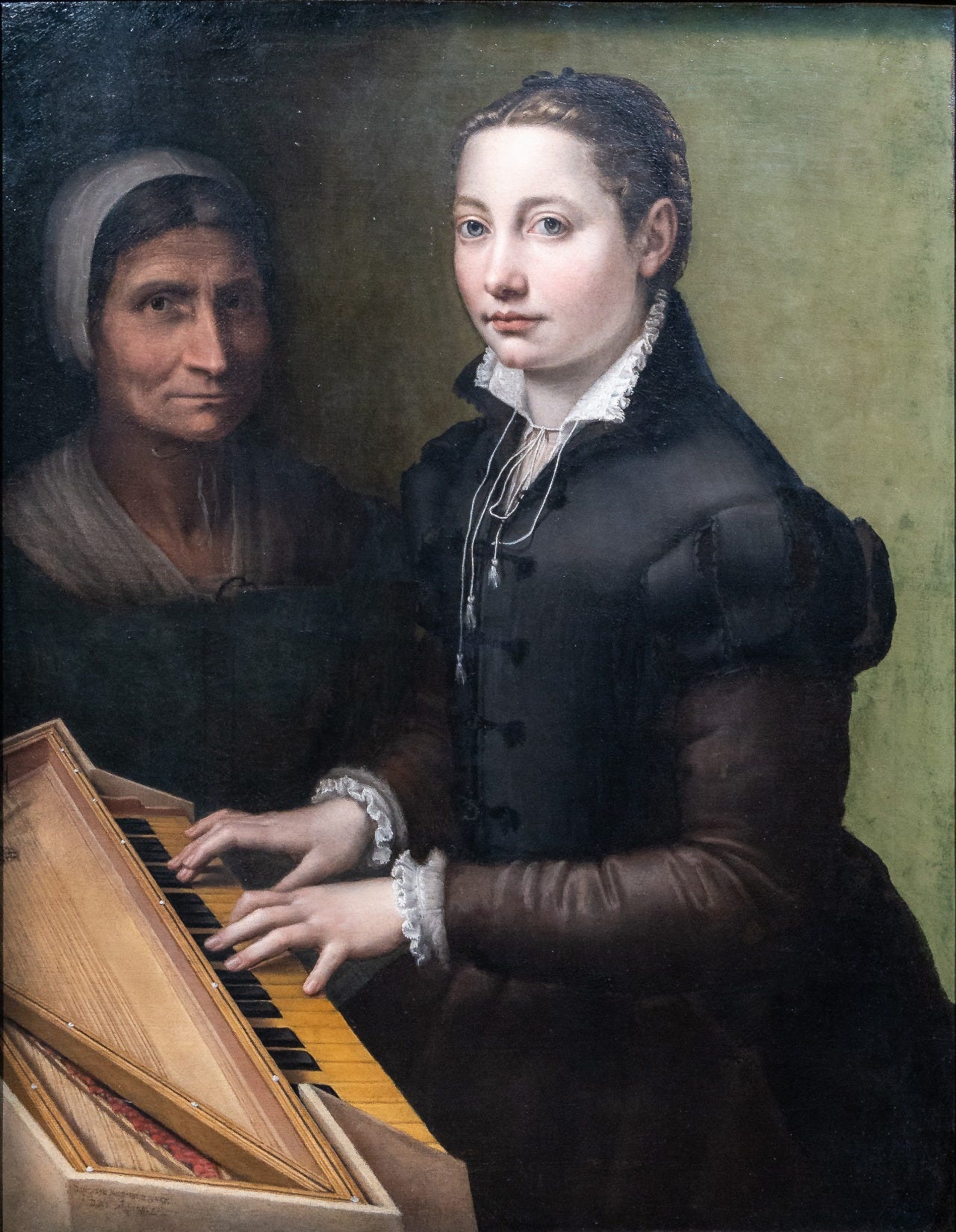 A young woman in black playing a small keyboard, an old woman in a white cap behind her A young woman in black playing a small keyboard, an old woman in a white cap behind her