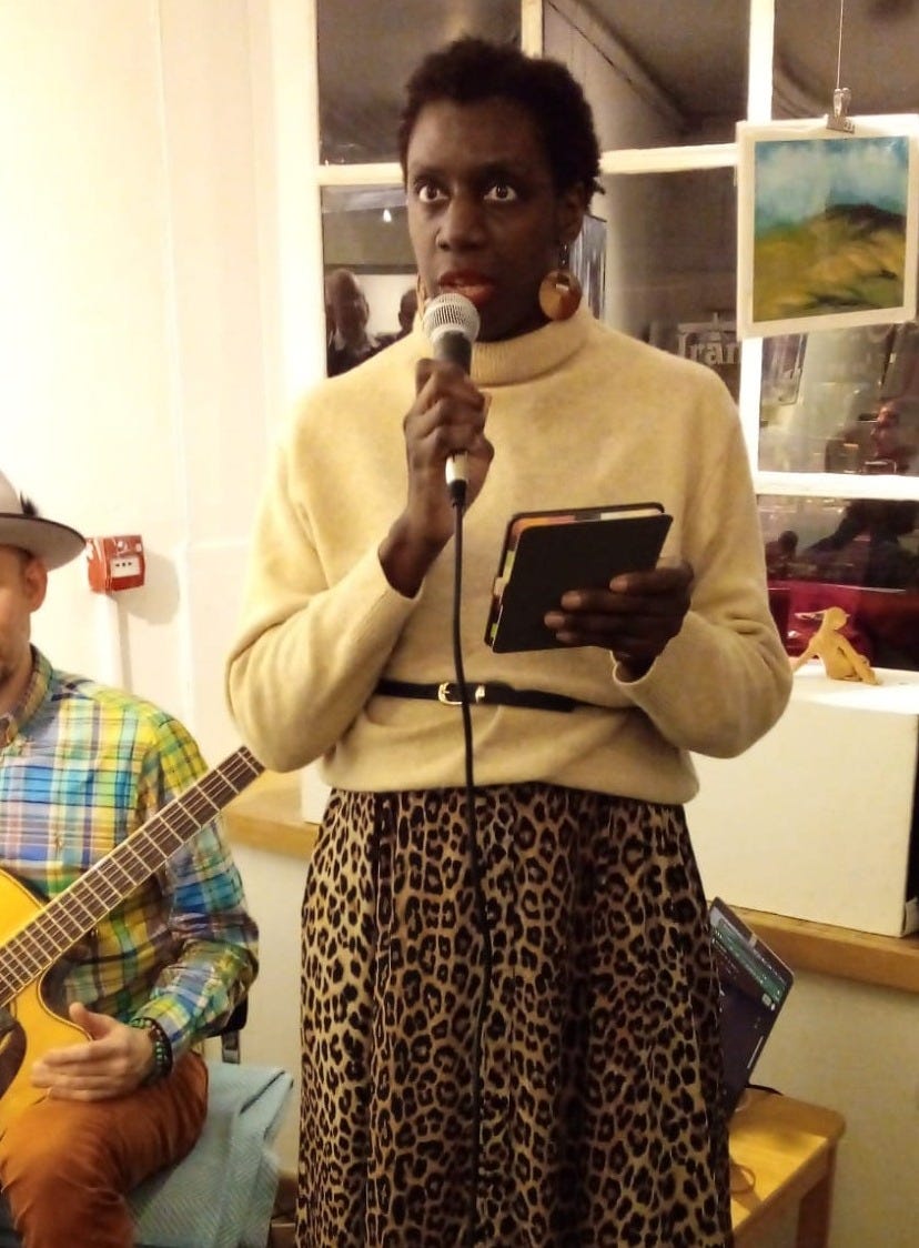 Adukeh performing holding a mic and Kindle.