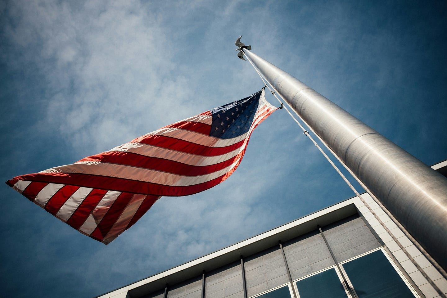 The American flag flies at half staff outside a government building. The American flag flies at half staff outside a government building.
