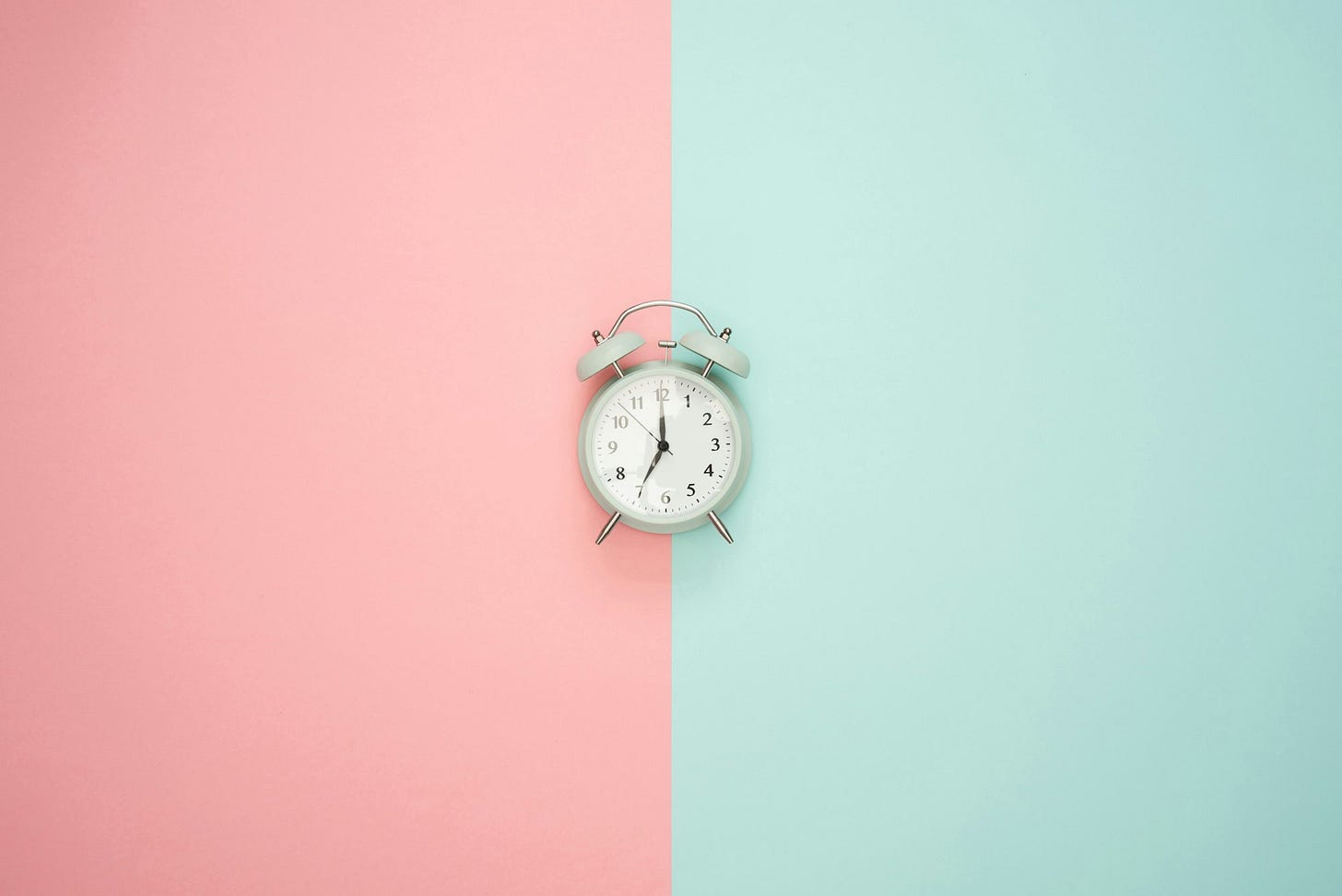 a clock on a half pink half blue background a clock on a half pink half blue background