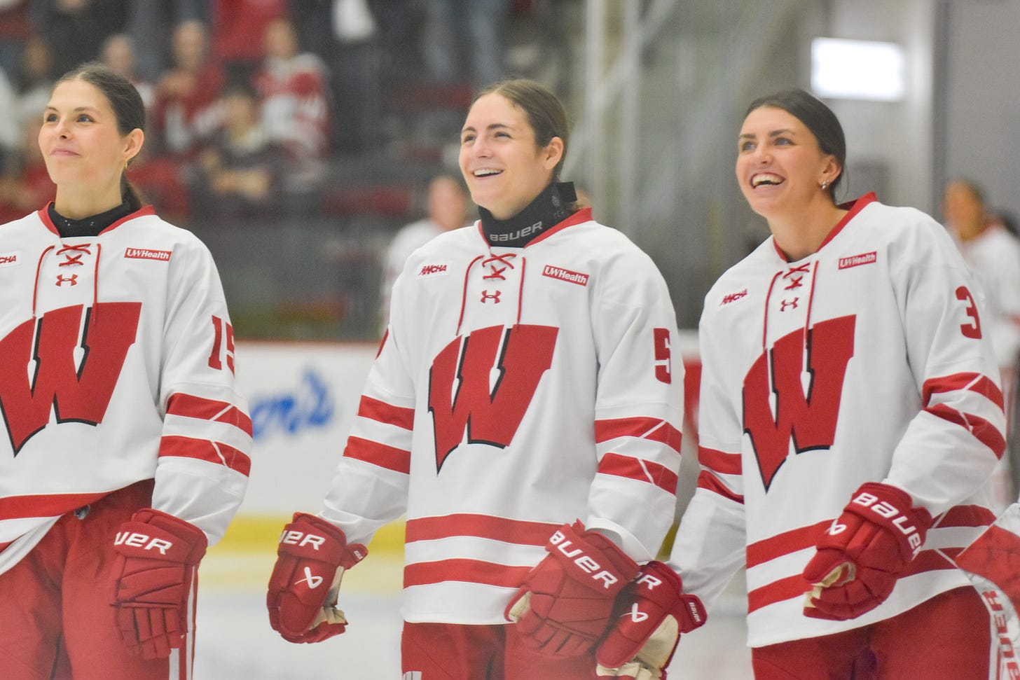 Wisconsin hockey players smile while looking forward