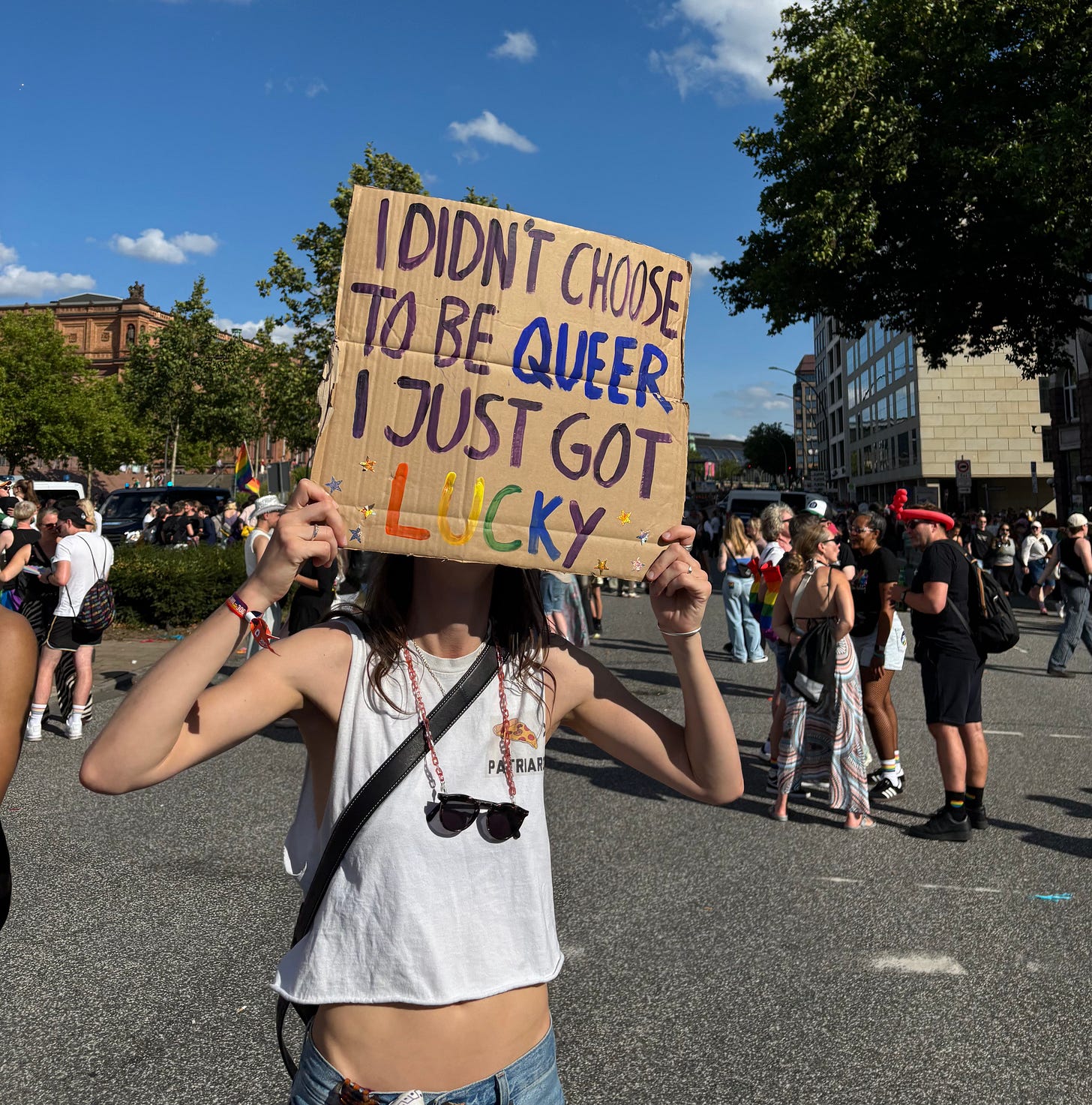 Someone at Hamburg Pride holding a sign over their face that reads "I didn't choose to be queer, I just got lucky." Someone at Hamburg Pride holding a sign over their face that reads "I didn't choose to be queer, I just got lucky."