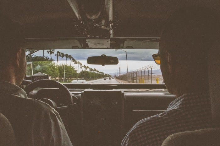 Two men driving in a car through Las Vegas.