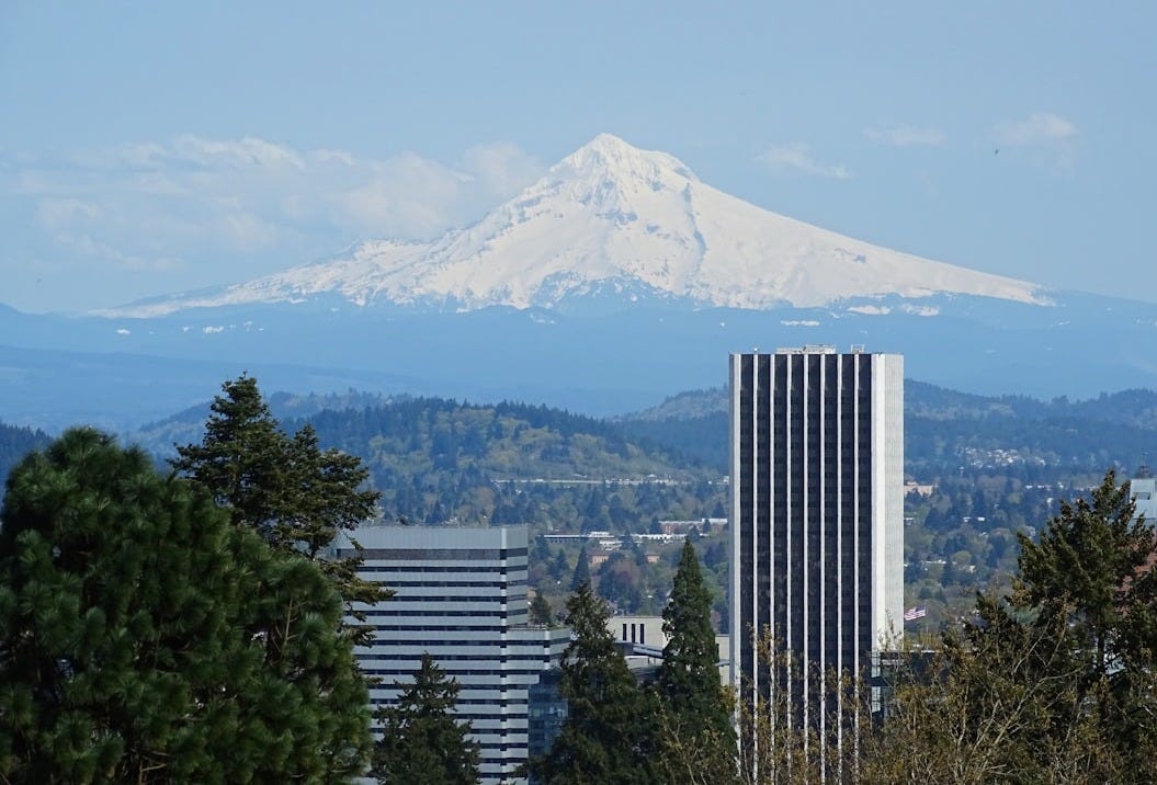 a tall building with a mountain in the background a tall building with a mountain in the background