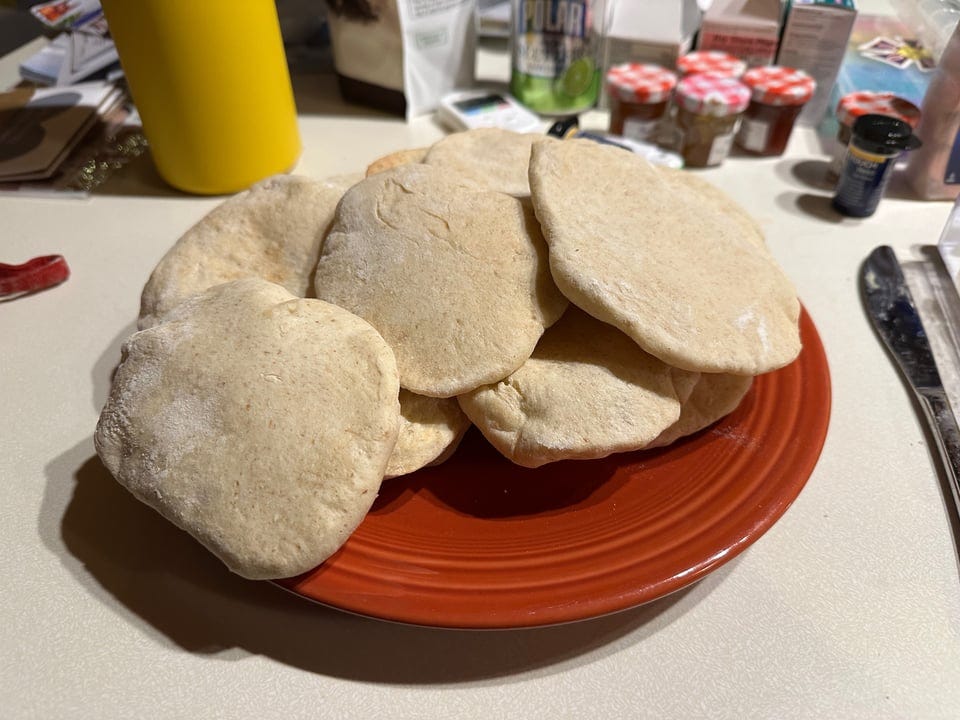 An orange plate with a pile of pitas on it