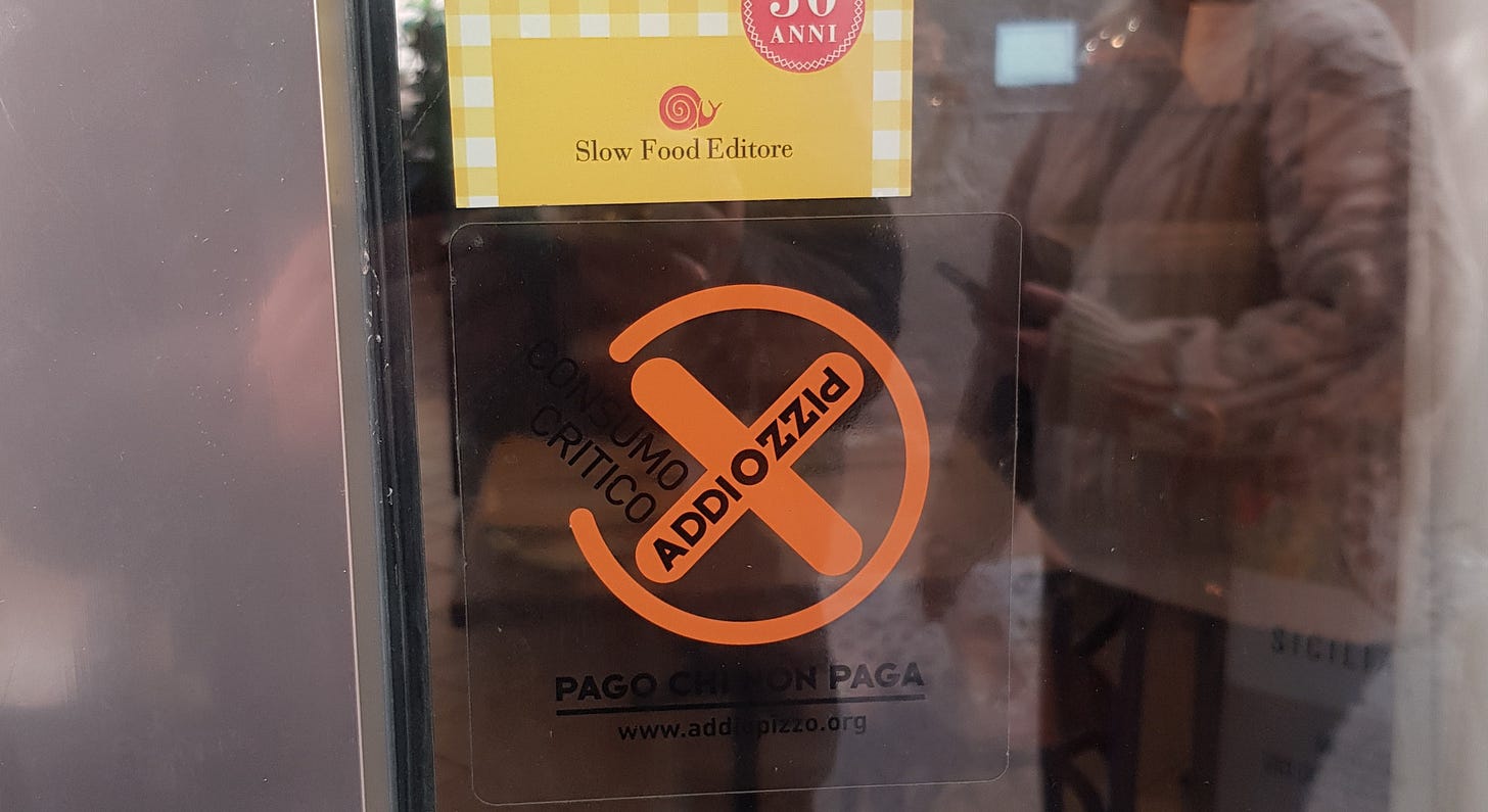 a glass restaurant door displays an orange anti-mafia sticker