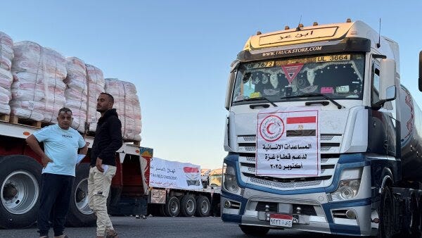 Trucks loaded with humanitarian aid on the Egyptian side of the Rafah crossing wait to cross into the Gaza Strip early on Oct. 15.