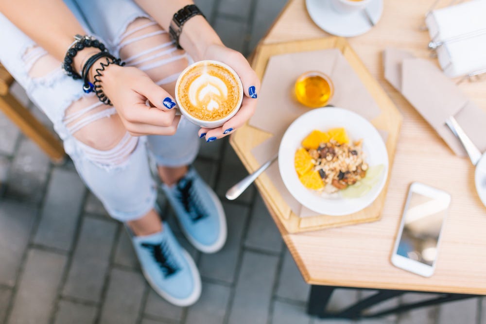 Young woman drinking coffee on her terrace.