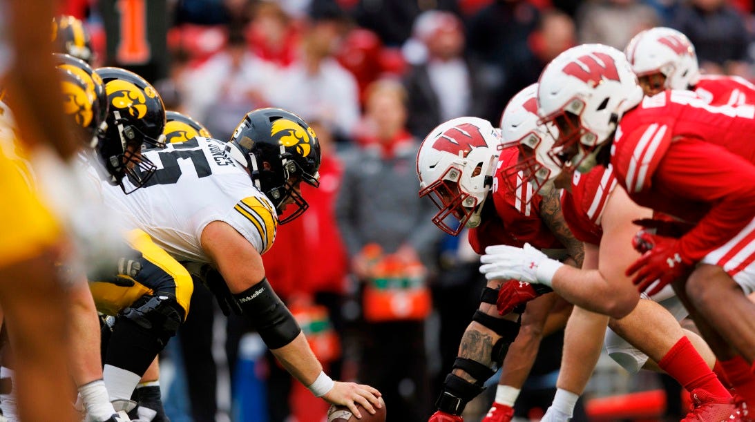 Wisconsin Badgers and Iowa Hawkeyes linemen face off at the line of scrimmage
