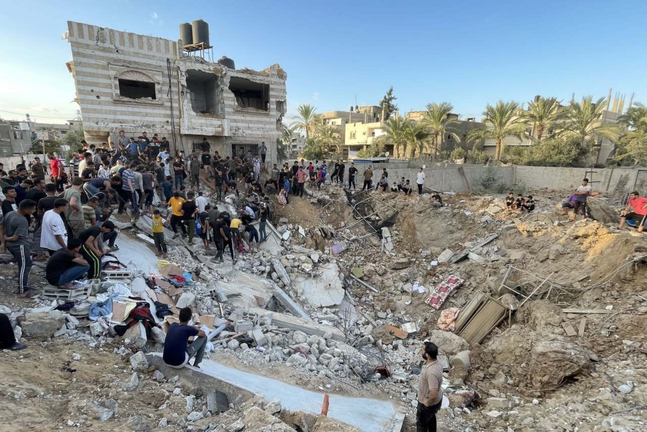People gathered around rubble of houses in Gaza hit by air strike 