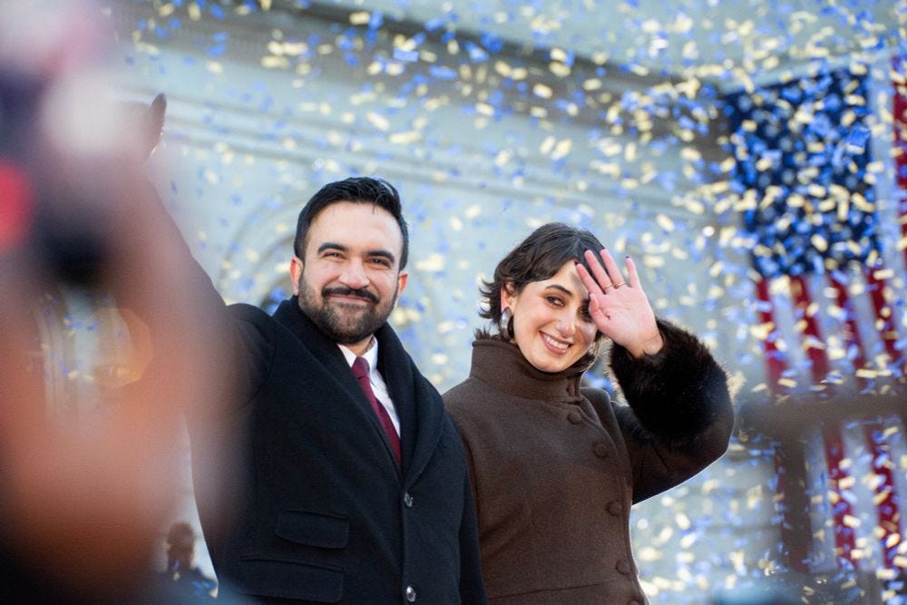 Zohran Mamdani and Ruwa Duwaji wave to the crowd as confetti falls around them on Inauguratino Day. Zohran Mamdani and Ruwa Duwaji wave to the crowd as confetti falls around them on Inauguratino Day.