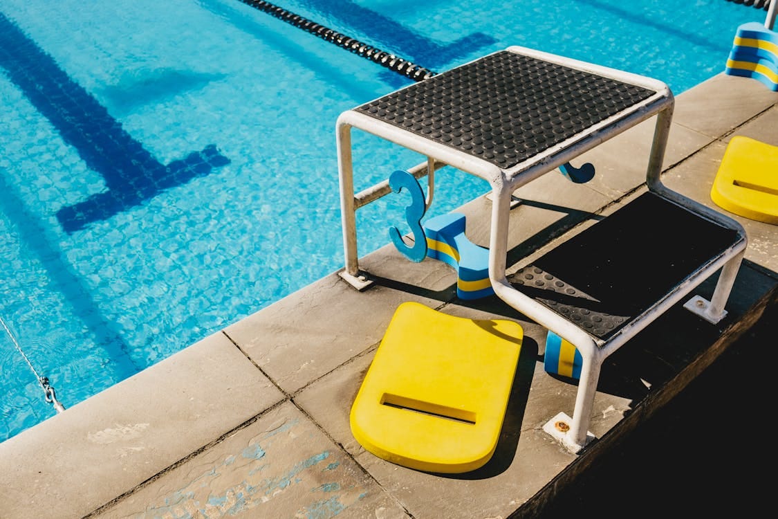 Free Vibrant swimming pool scene with a starting block and lane markers on a sunny day. Stock Photo