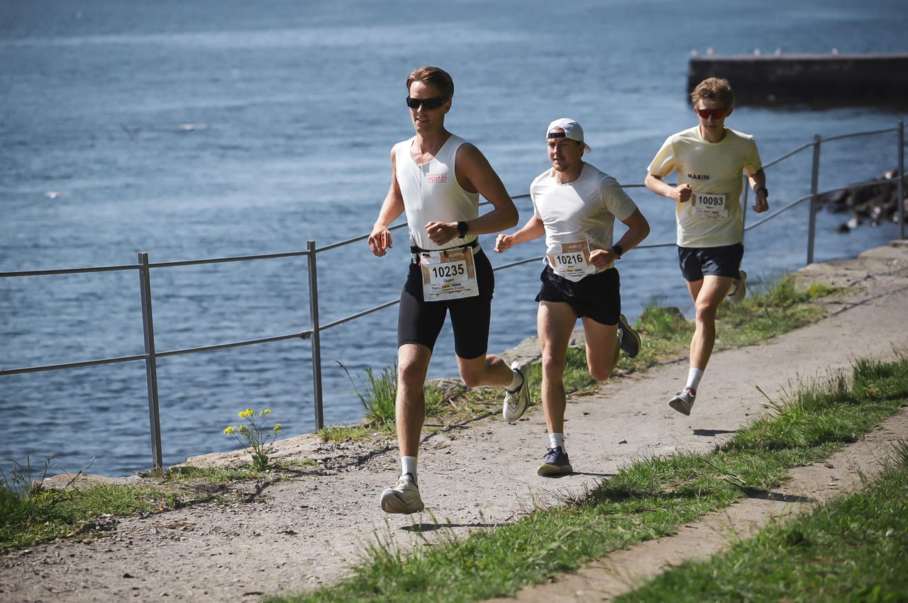 EcoTrail Oslo runners racing along a waterfront trail in Oslo EcoTrail Oslo runners racing along a waterfront trail in Oslo