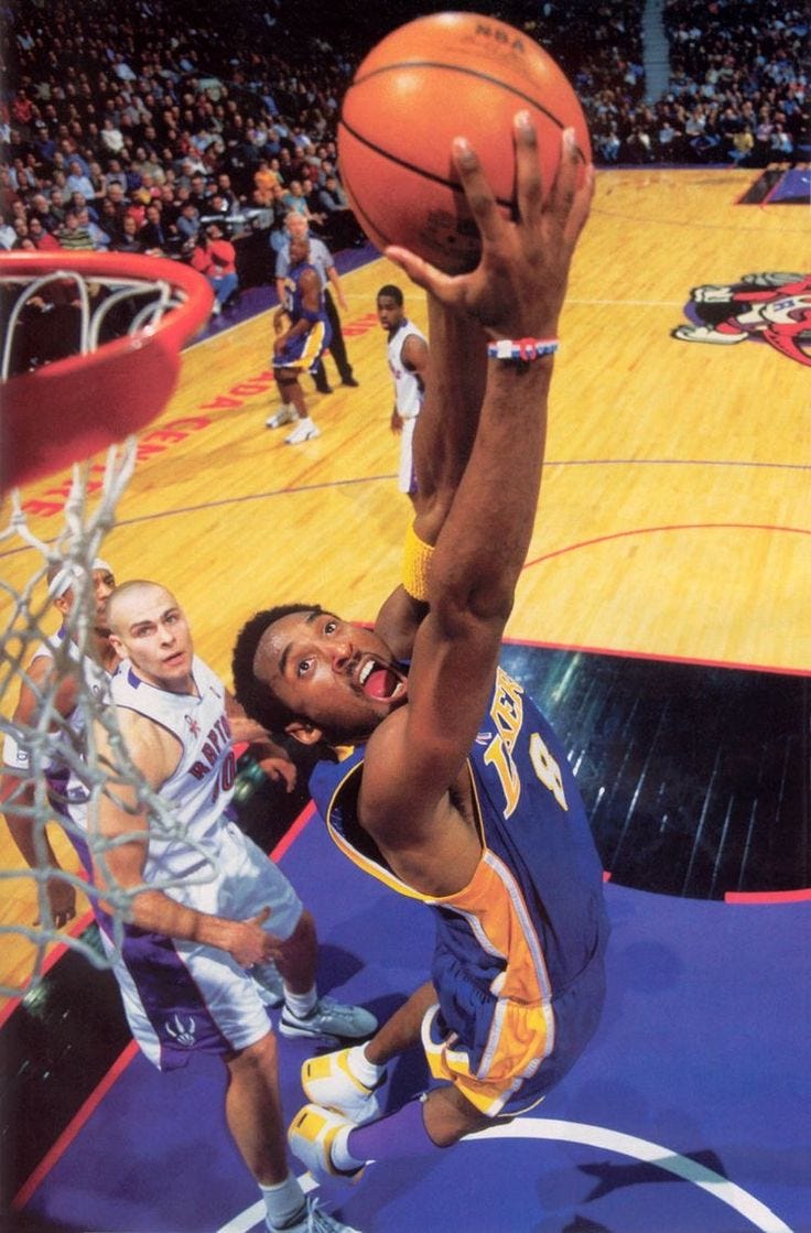 This may contain: the basketball player is trying to dunk the ball into the hoop while people look on This may contain: the basketball player is trying to dunk the ball into the hoop while people look on