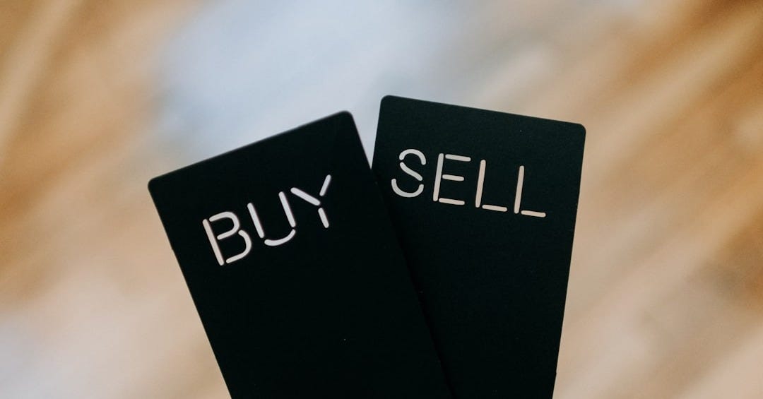 a hand holding two black cards with the words buy and sell written on them a hand holding two black cards with the words buy and sell written on them