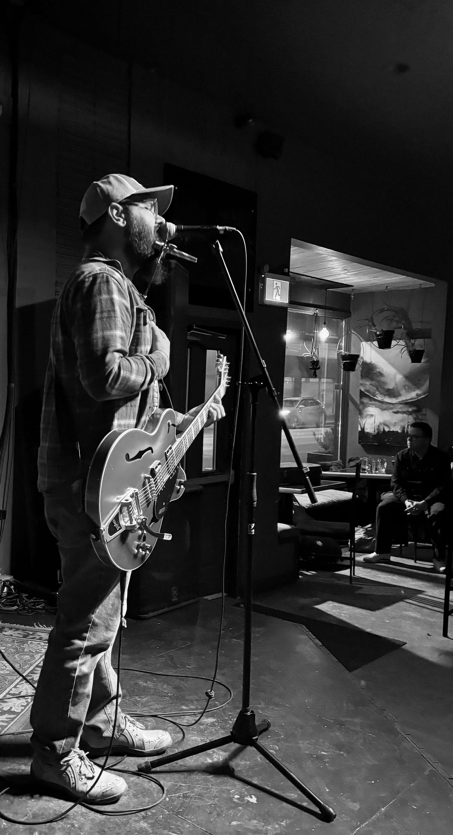 A moody black and white photo of Jeremy and his Kazoo performing.