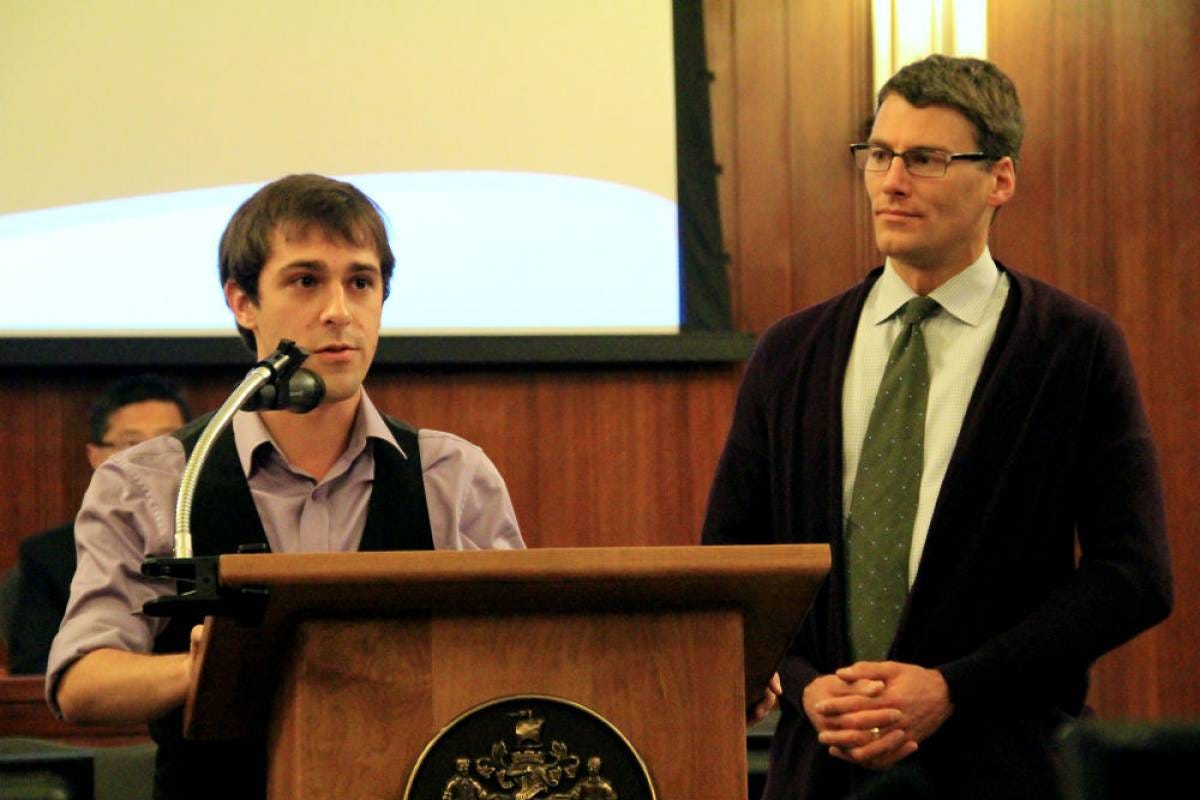 Me at a podium at city hall next to Mayor Gregor Robertson