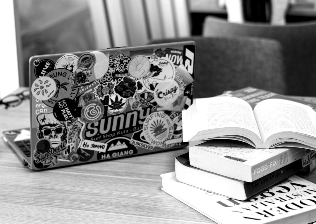 Laptop and books sit on a wooden table. Laptop and books sit on a wooden table.