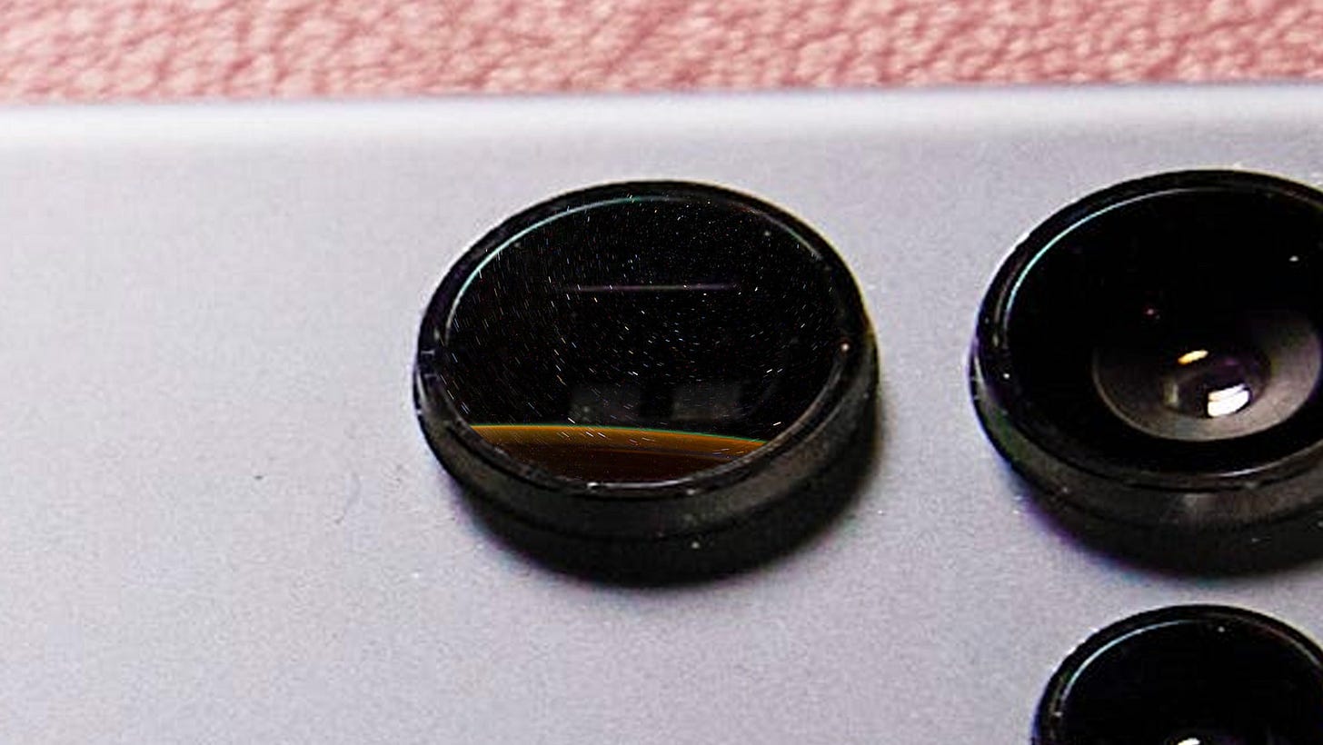 A close-up of the telephoto lense with a timelapse shot of stars superimposed on it