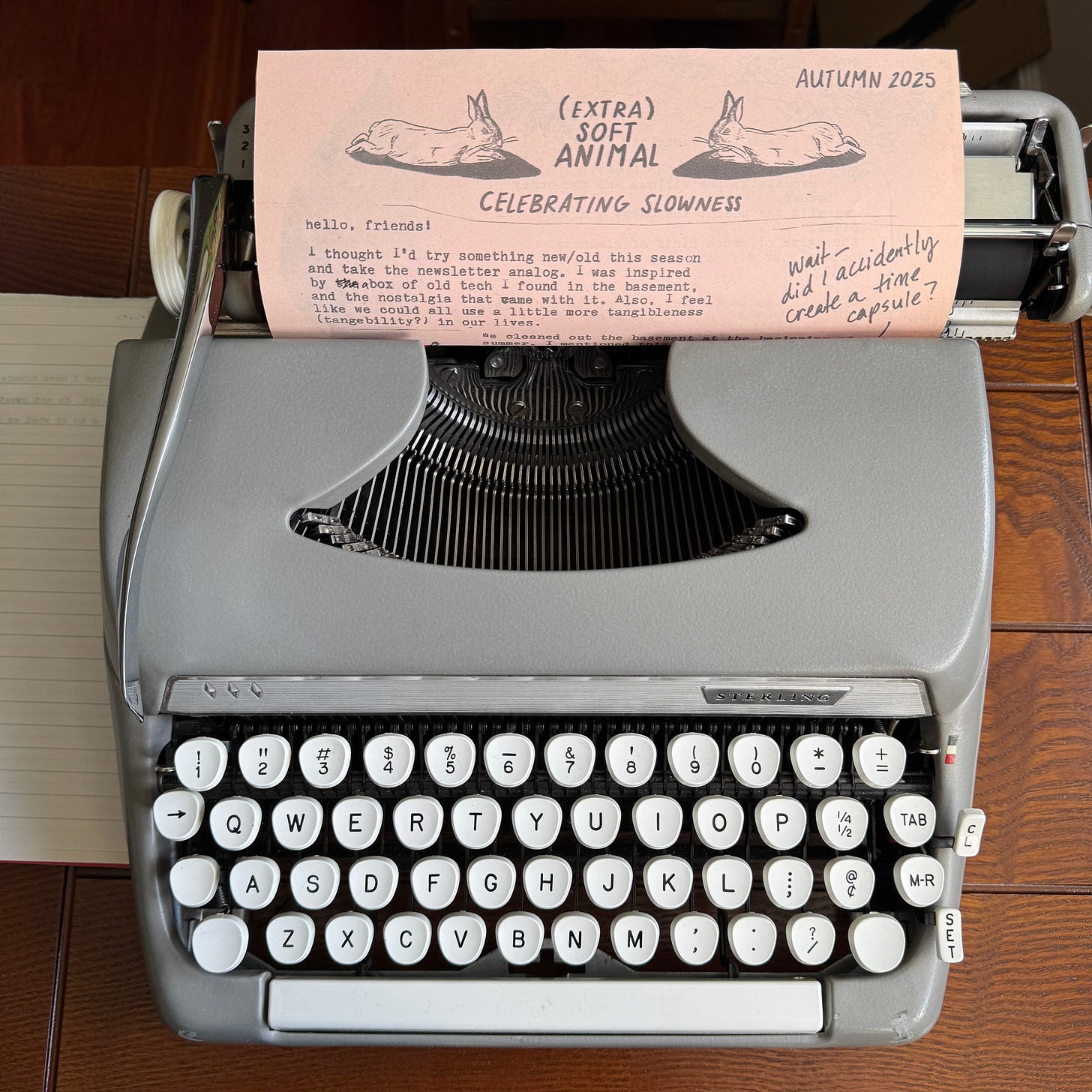 a photograph of the physical newsletter in question, sitting atop a gray manual typewriter a photograph of the physical newsletter in question, sitting atop a gray manual typewriter