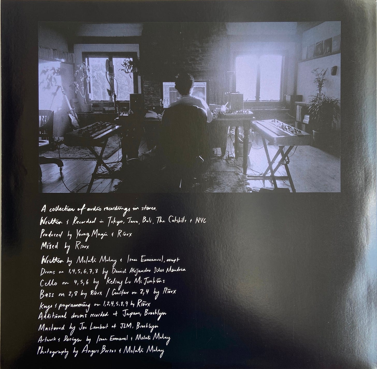 a musician sits in a studio surrounding by recording equipment. the credits for Still Life by Young Magic appear below the photograph on the album's record sleeve.