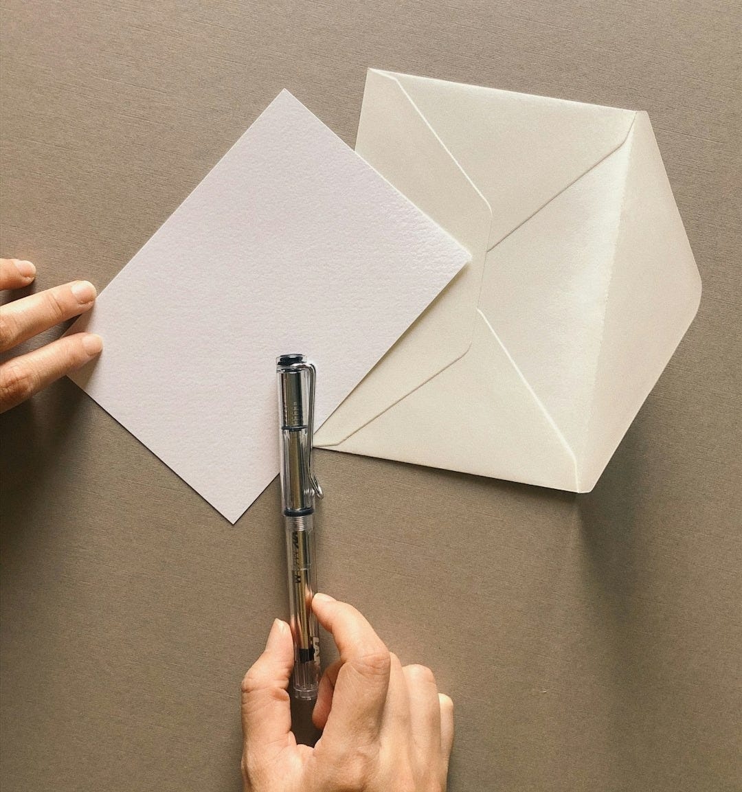 a person cutting out a piece of paper with a pen