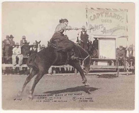 Photo of a pioneer woman riding a bucking horse while men and horses watch