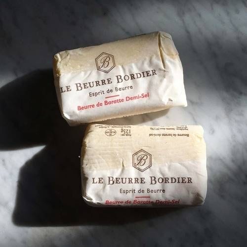 This may contain: two bars of soap sitting on top of a marble countertop next to each other