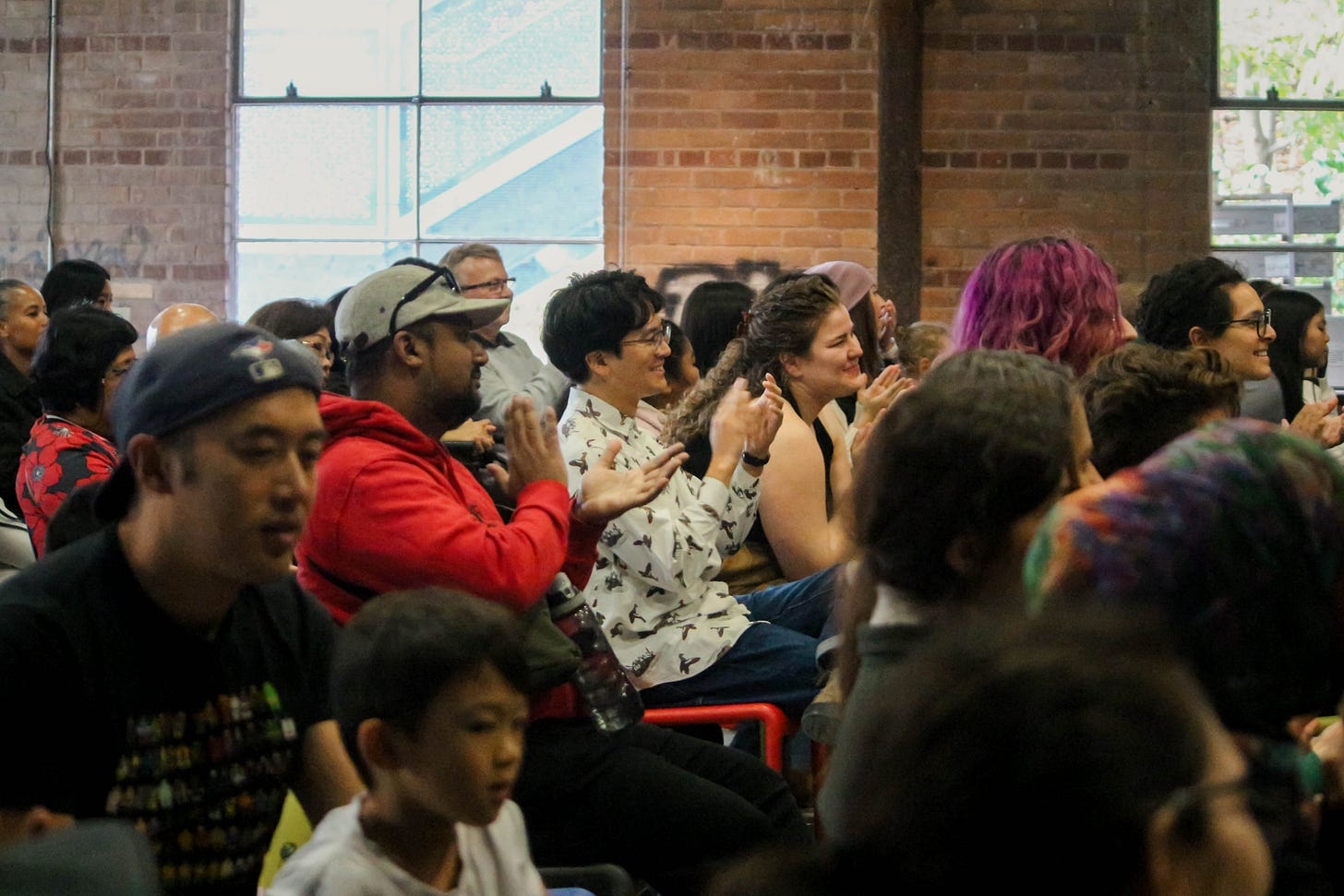People sitting in a crowd clapping.