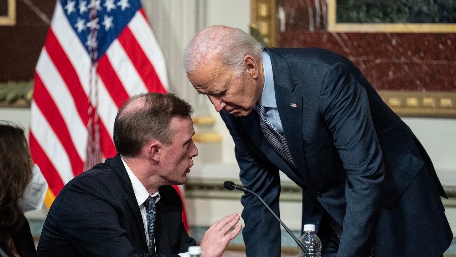 Biden leaning over Sullivan who is speaking in his ear Biden leaning over Sullivan who is speaking in his ear
