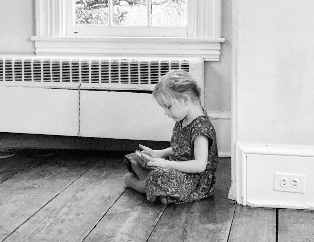 Young girl sitting on floor reading a book