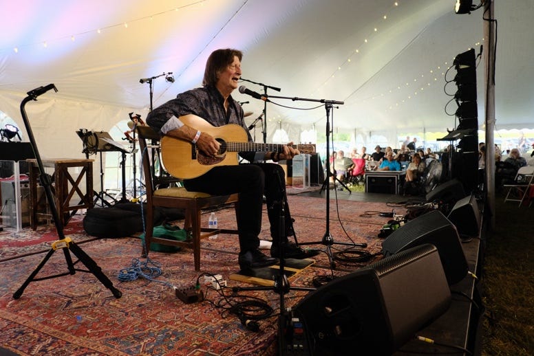 A person playing guitar on stage

Description automatically generated