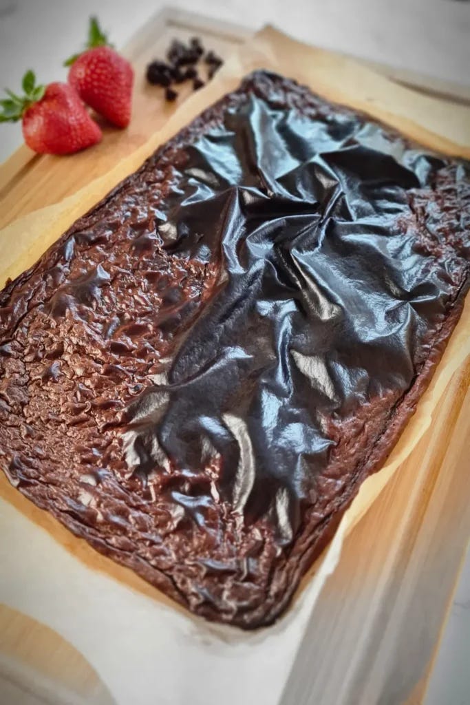A delectable Chocolate Cottage Cheese Flatbread, freshly made and displayed on a wooden cutting board. The flatbread has a luscious chocolate topping with a textured surface, hinting at its moist and rich flavor. Accompanied by fresh strawberries and chocolate chips in the background, this image showcases the key ingredients, making it an inviting treat for those following a keto diet. A delectable Chocolate Cottage Cheese Flatbread, freshly made and displayed on a wooden cutting board. The flatbread has a luscious chocolate topping with a textured surface, hinting at its moist and rich flavor. Accompanied by fresh strawberries and chocolate chips in the background, this image showcases the key ingredients, making it an inviting treat for those following a keto diet.