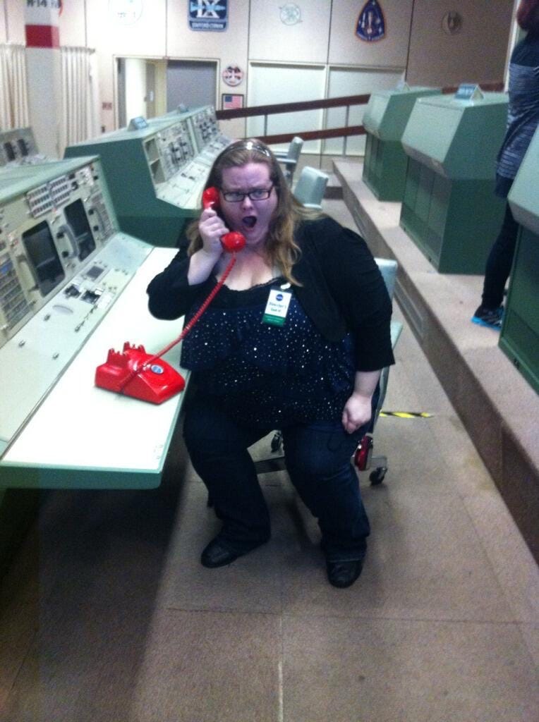 A picture of author Beth Revis sitting at the console of the space center, on the red NASA telephone A picture of author Beth Revis sitting at the console of the space center, on the red NASA telephone