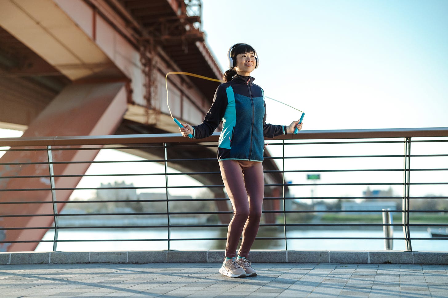 Woman jumping rope outside in an urban environment. Woman jumping rope outside in an urban environment.
