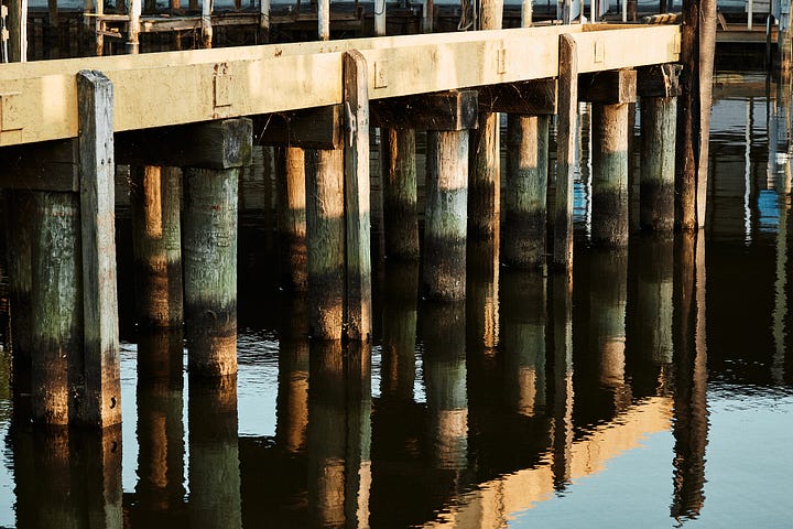 Yellow and blue-green color palette of water and a painted boat lift