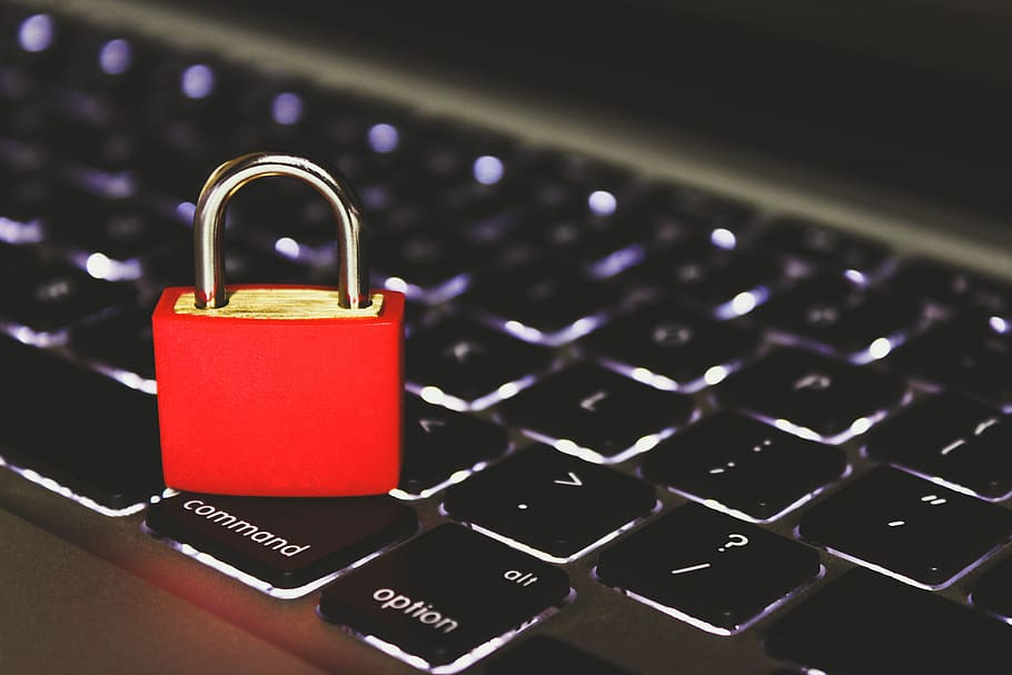 A laptop keyboard with a red pad lock on it, currently locked