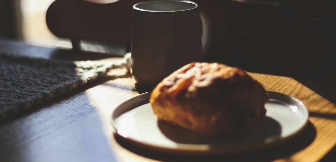 a cup of coffee and a biscuit on a plate