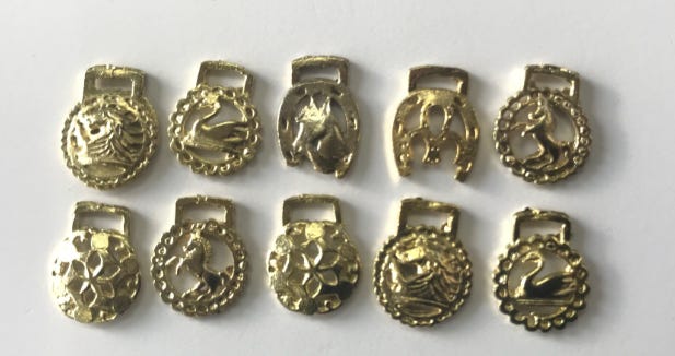 A group of gold horse buckles

AI-generated content may be incorrect.