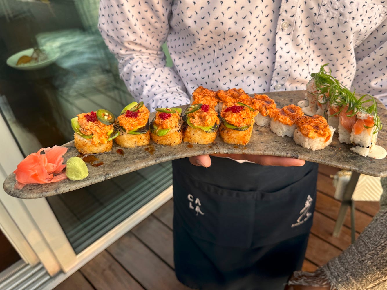 Waiter at Cala presenting of platter of Peruvian makis