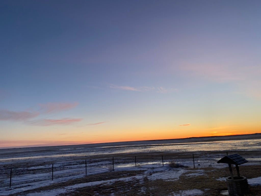 A sunset over a snowy field

Description automatically generated