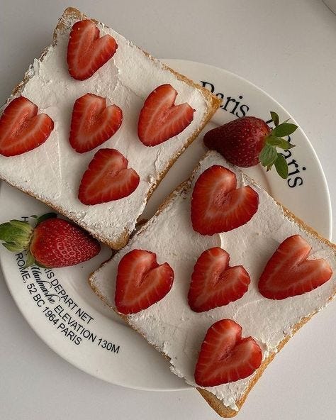 Picture of strawberries cut into hearts and placed on toasted bread with cream cheese.
