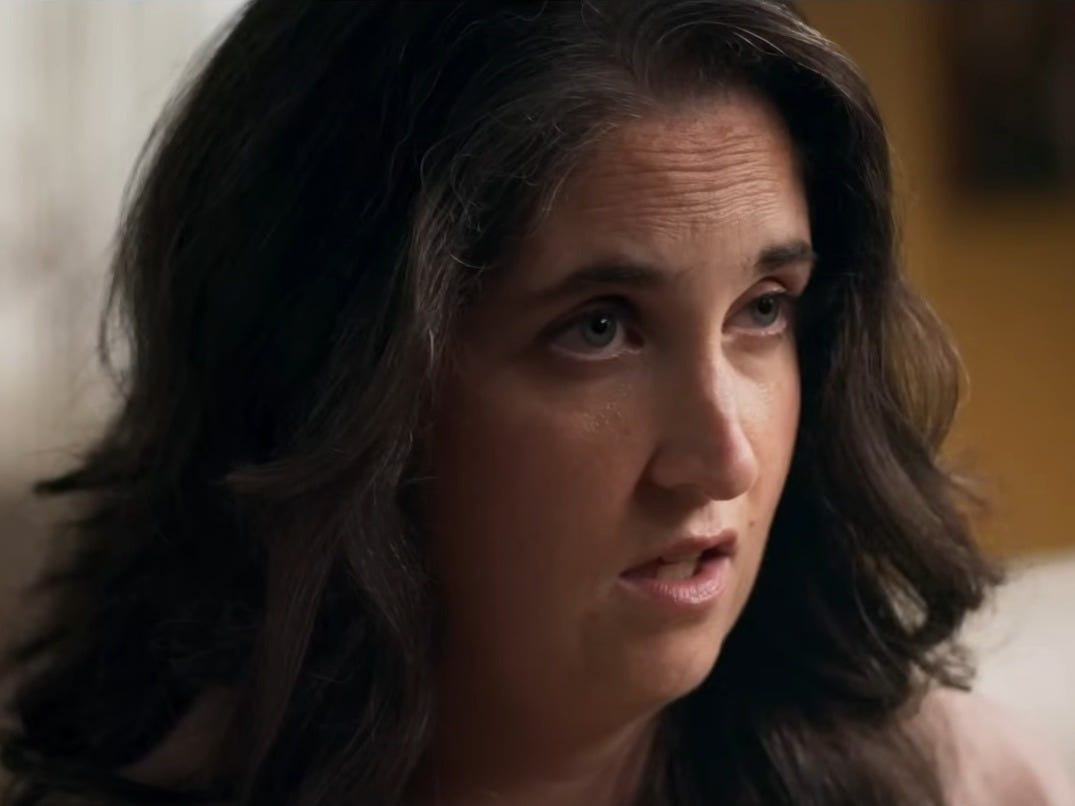 Close up of Jennifer Beyer, woman with her brown hair down and pink lipstick on.
