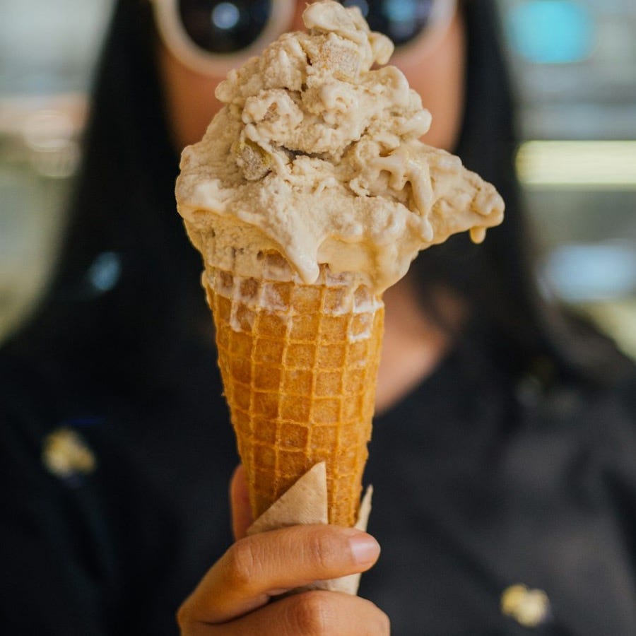 a woman wearing sunglasses holding an ice cream cone