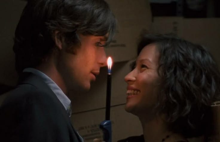 This may contain: a woman standing next to a man with a candle in his mouth This may contain: a woman standing next to a man with a candle in his mouth
