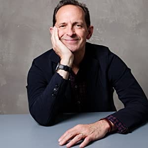Photo of Charles Marsh sitting with hand on table other hand on chin and smiling